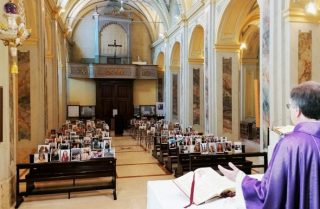 Mentre il coronavirus svuota le chiese, il prete riempie i banchi con le foto dei parrocchiani