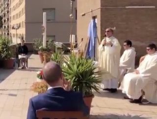 Il sacerdote a Roma offre la messa di Pasqua sul tetto della chiesa in mezzo alla quarantena di Coronavirus